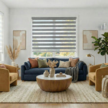 Load image into Gallery viewer, Ash Grey Zebra Solar Roller Shades in Living room with a blue sofa, mustard chairs, and a wooden coffee table.
