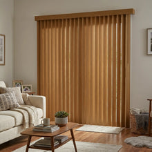 Load image into Gallery viewer, Brown Wood Grain Faux Wood PVC Vertical Blinds harmonize with white walls and beige carpet, filtering sunlight in this serene living space.