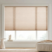 Load image into Gallery viewer, Sunlight hits the Beige (Pongee) 7 16 Inch Double Cell Light Filtering Shades in this cozy living room, providing excellent UV protection and a soft ambient light.