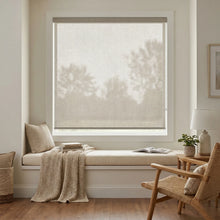 Load image into Gallery viewer, Classic Fabric Light Filtering Roller Shades in beige enhance the cozy ambiance of this inviting living space, filtering natural light while maintaining privacy.