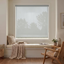 Load image into Gallery viewer, Classic Fabric Light Filtering Roller Shades in beige enhance the cozy ambiance of this inviting living space, filtering natural light while maintaining privacy.