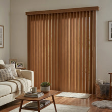 Load image into Gallery viewer, Wood Grain Faux Wood PVC Vertical Blinds with warm brown tones beautifully complementing a serene bedroom, featuring plush gray carpet and elegant wood furniture