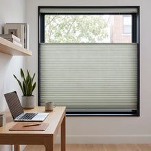 Load image into Gallery viewer, Simplistic Cordless Tdbu Pleated Shades in cream effortlessly filter natural light, casting a warm glow on this studious space, where wood and greenery converge.