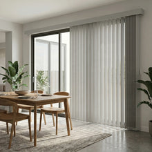 Load image into Gallery viewer, This inviting living space is equipped with Creamy (Evelyn Soft Grey) Premier Pvc Vertical Blinds, delivering sleek functionality and room-darkening capabilities.