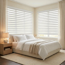 Load image into Gallery viewer, Elevate your bedroom's ambiance with Zebra Light Filtering Roller Shades in creamy white, perfect for a serene retreat.
