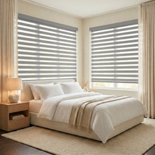 Load image into Gallery viewer, Zebra Light Filtering Roller Shades bring subtle gray tones and versatile functionality to this modern bedroom, perfect for filtered natural light.