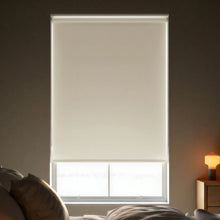 Load image into Gallery viewer, Close-up view of Ivory Signature room darkening roller shades, showing the fabric texture and clean window fit.