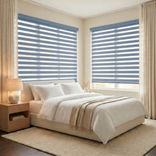Load image into Gallery viewer, Soft light filtering through Zebra Light Filtering Roller Shades in calming light blue, perfect for bedroom ambiance.