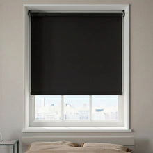 Load image into Gallery viewer, Main view of Matte Vinyl Black ProGrade blackout roller shades providing total light blockage in a bright modern bedroom.