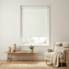 Load image into Gallery viewer, Main view of Milky Light Beige Luxe fabric blackout roller shades in a sun-drenched living room featuring minimalist wooden furniture and neutral decor.