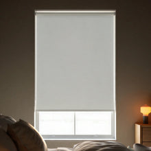 Load image into Gallery viewer, Close-up view of Off White Oyster Signature room darkening roller shades, showing the fabric texture and clean window fit.