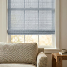 Load image into Gallery viewer, Introducing Cordless Woven Wood Shades in Sky Blue, effortlessly filtering sunlight while complementing sleek furnishings and fostering a calming ambiance in this serene retreat.