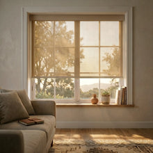 Load image into Gallery viewer, Main view of a Tan Sandstone Signature solar roller shade with 5% openness in a sun-drenched living room, showcasing effective glare control while maintaining an outdoor view.