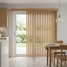 Load image into Gallery viewer, Warm light wood textured woodgrain finish vertical blinds with 3 1/2" vanes in a kitchen setting