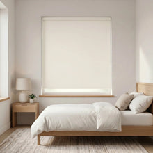 Load image into Gallery viewer, Economy Basic Vinyl Blackout Roller Shades in a serene bedroom setting, providing a sleek white backdrop for a cozy atmosphere.