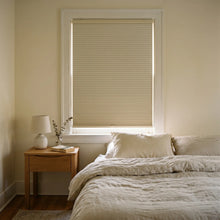 Load image into Gallery viewer, This minimalist bedroom is enhanced by Winter White 9 16 Inch Classic Single Cell Blackout Cordless Shades, creating a serene, light-free setting.