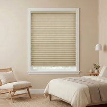 Load image into Gallery viewer, Beige pleated window shades in a bedroom with a bed and chair.
