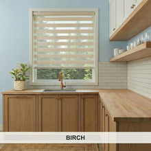 Load image into Gallery viewer, Birch Zebra Solar Roller Shades in kitchen with wooden cabinets, countertop.
