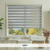 Kitchen window with gray zebra blinds, countertop with kitchen items, and plant.
