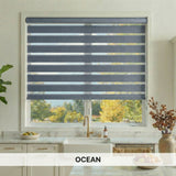 Kitchen window with zebra blinds labeled 'OCEAN', showing a view of trees outside.