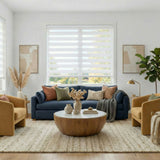 White Zebra Solar Roller Shades in modern living room with a blue sofa, wooden coffee table, and yellow armchairs.
