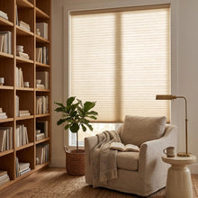 Load image into Gallery viewer, Simplistic Cordless Pleated Shades' soft beige hue harmonizes with wooden furniture, white walls, and book-lined shelves in this inviting study, creating a warm and intelligent atmosphere.
