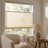 Simplistic Cordless Tdbu Pleated Shades effortlessly filter bright sunlight through beige treatments, complementing white walls and furniture in this serene room where versatility meets relaxation.