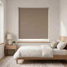 Load image into Gallery viewer, Economy Basic Vinyl Blackout Roller Shades in a neutral beige tone, creating a cozy atmosphere in this serene bedroom setting.

