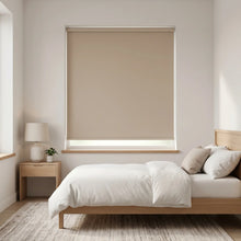 Load image into Gallery viewer, Economy Basic Vinyl Blackout Roller Shades adorn a serene beige bedroom, creating a cozy atmosphere with their efficient light-blocking capabilities.

