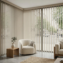 Load image into Gallery viewer, Natural sunlight hits the Beige (Pagoda Dusk Grey) Signature Pvc Vertical Blinds in this warm living space, perfect for covering sliding glass doors or large windows.
