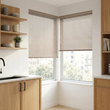 Load image into Gallery viewer, Natural sunlight hits the Beige Taupe Classic Cordless 6g Aluminum Mini Blinds in a cozy home, managing sunlight effectively with easy-to-tilt aluminum slats.
