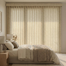 Load image into Gallery viewer, Signature Collection Fabric Vertical Blinds in Beige expertly filter soft morning light, complementing white sheets and gray accents in this serene bedroom oasis.

