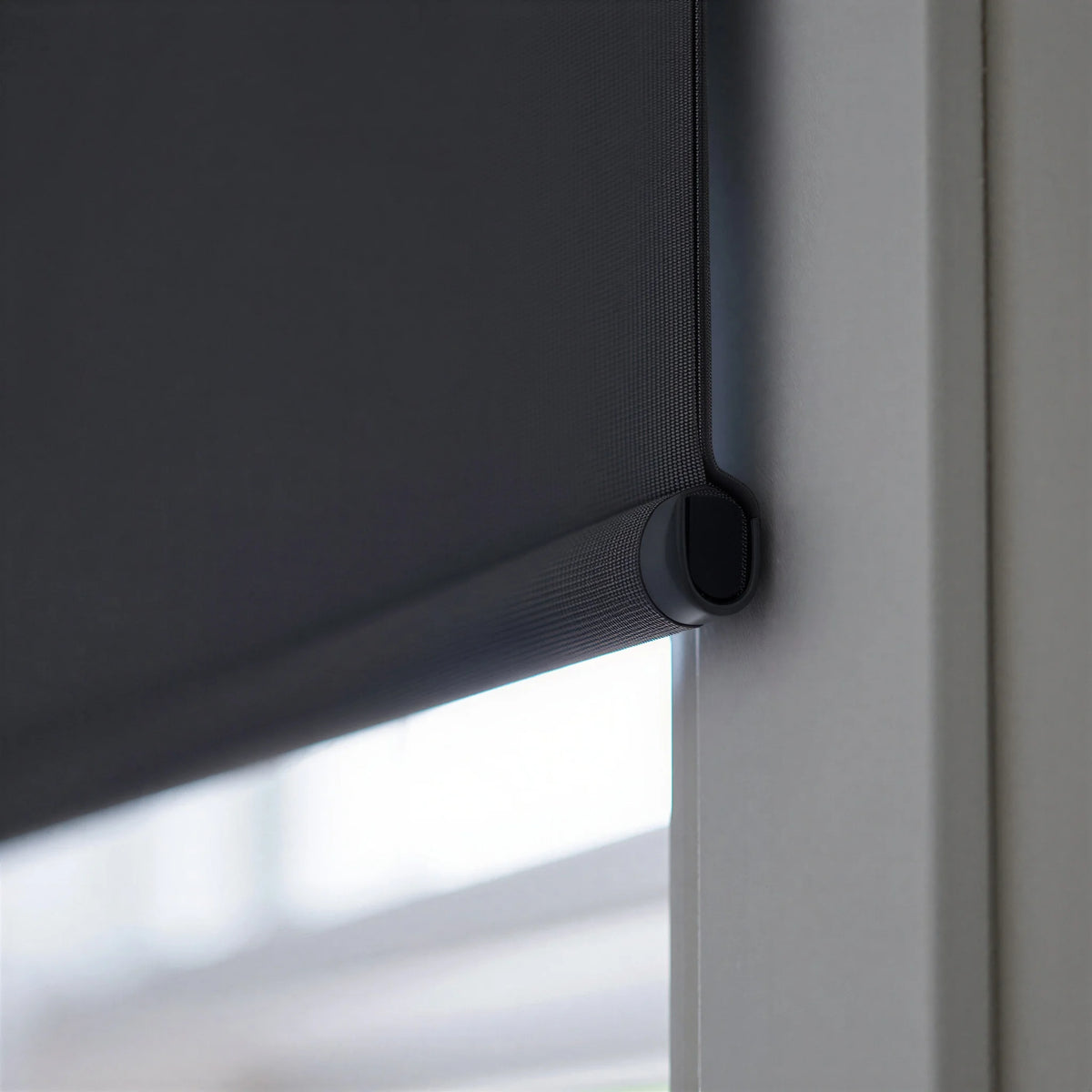 Extreme macro close-up of the black fabric-wrapped hem bar on a ProGrade blackout roller shade, showing the premium finish.
