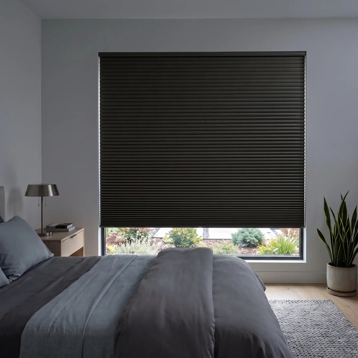 Black Gala-Night Signature Blackout Double Cellular Shade on a bedroom window beside a wood nightstand