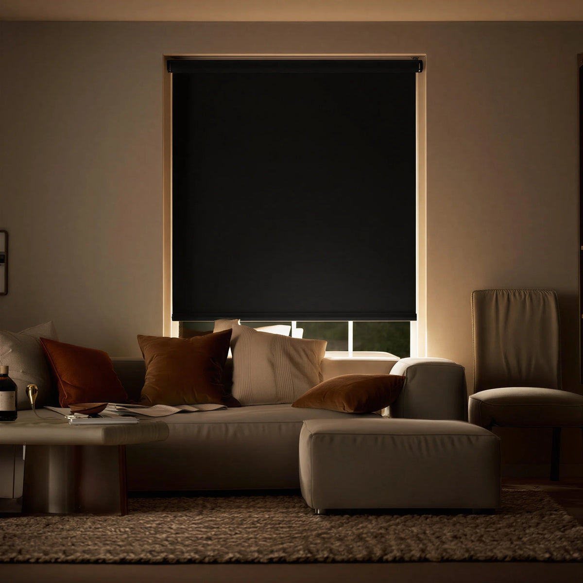 Black ProGrade blackout roller shades in a living room setting, creating a high-contrast look with neutral furniture.