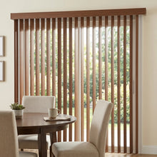 Load image into Gallery viewer, Wood Grain Faux Wood PVC Vertical Blinds perfectly complement the beige furniture and white tablecloth in this elegant room, inviting natural light and sophistication.
