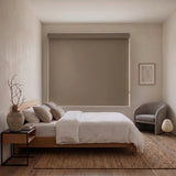 Brown Classic Blackout Vinyl Roller Shade fully blocking light in a minimalist bedroom