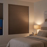 Brown Taupe-Notch Signature Blackout Double Cellular Shade on a bedroom window beside a wood nightstand