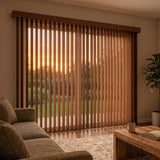Wood Grain Faux Wood PVC Vertical Blinds beautifully complement the warm ambiance of this living room, where a brown couch and potted plant create a cozy atmosphere.