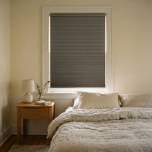Load image into Gallery viewer, A peaceful bedroom featuring Charcoal (Antique Pewter) 9 16 Inch Classic Single Cell Blackout Cordless Shades, shielding the interior from bright daylight and street lamps.
