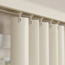 Load image into Gallery viewer, View of a serene living room with Cream 3 1/2 Inch Classic Curved Pvc Smooth Vertical Blinds, providing durable, easy-to-clean window coverage.
