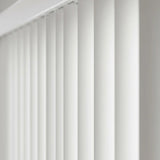 View of a serene living room with Cream Premier Pvc Vertical Blinds, ideal for expansive windows requiring versatile light management.