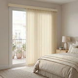 Signature Collection Fabric Vertical Blinds in Cream harmonize with natural light, beige bedspread and lush greenery in this serene bedroom oasis