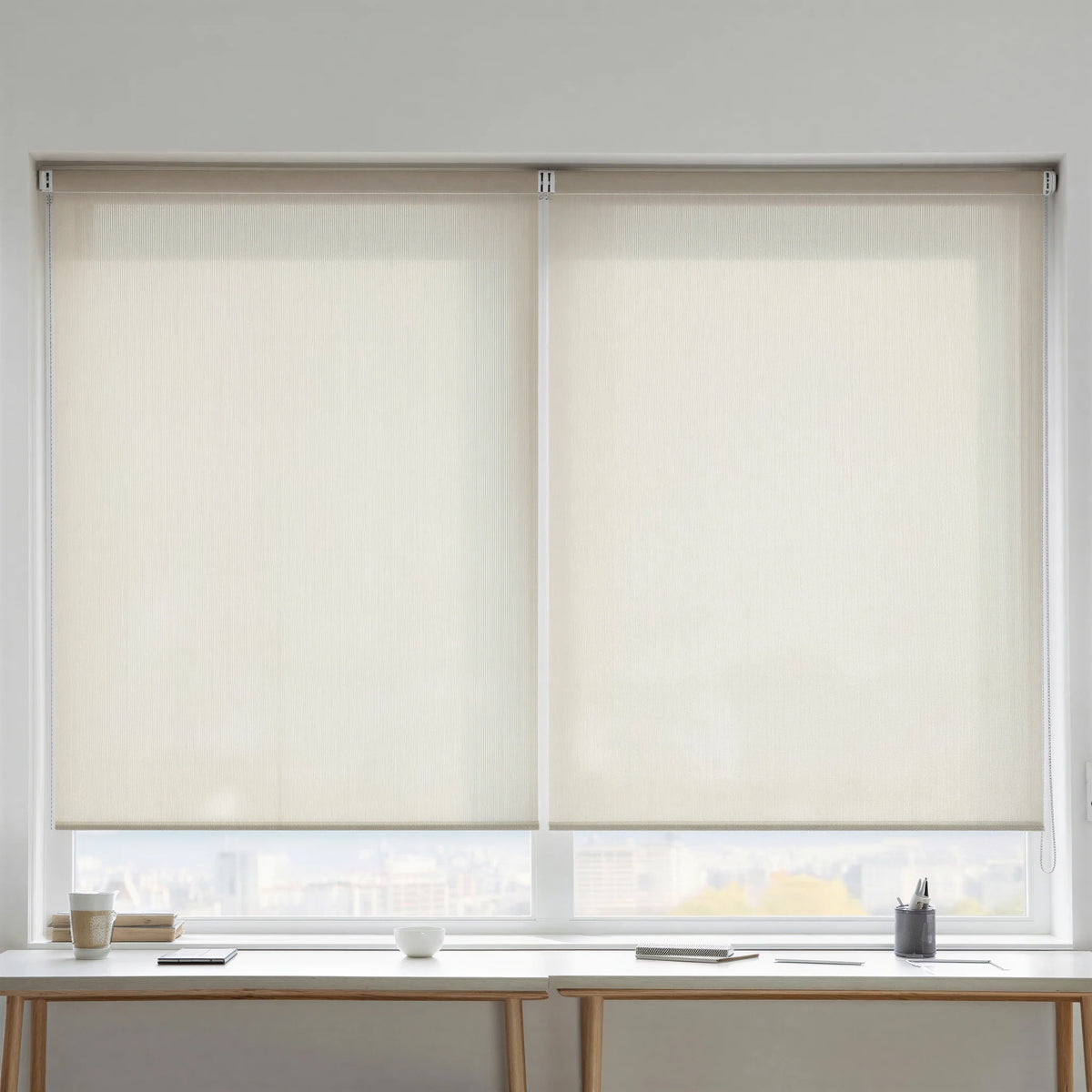 Creamy white Sandstone solar shades with 5 percent openness installed over a workspace to reduce screen glare.