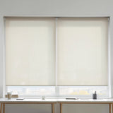 Creamy white Sandstone solar shades with 5 percent openness installed over a workspace to reduce screen glare.