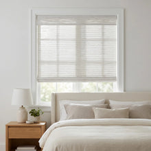 Load image into Gallery viewer, Cordless Woven Wood Shades beautifully filter natural light into this inviting bedroom, where a beige bedframe and creamy pillows create a peaceful retreat
