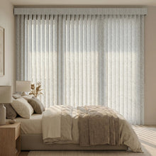 Load image into Gallery viewer, Signature Collection Fabric Vertical Blinds in Creamy White harmonize with a beige bedspread, creating a serene ambiance in this inviting bedroom sanctuary.
