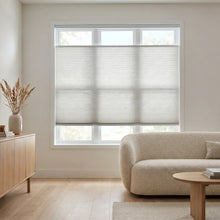 Load image into Gallery viewer, Sunlight hits the Creamy White (Gray Sheen) 9 16 Classic Single Cell Light Filtering Cordless Top Downbottom Up Cordless Shades in this warm living space, creating a bright atmosphere with complete control over your view.
