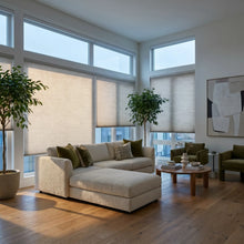Load image into Gallery viewer, Custom window treatments: Creamy White (3_Misty Grey) 9 16 Classic Single Cell Light Filtering Cordless Shades shown in a modern living space, gently filtering daylight to create a warm glow.
