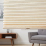 Simplistic Cordless Tdbu Pleated Shades harmonize with creamy white walls, beige fabric texture adding warmth to this inviting room where a gray couch and wooden side table create a comfortable seating area